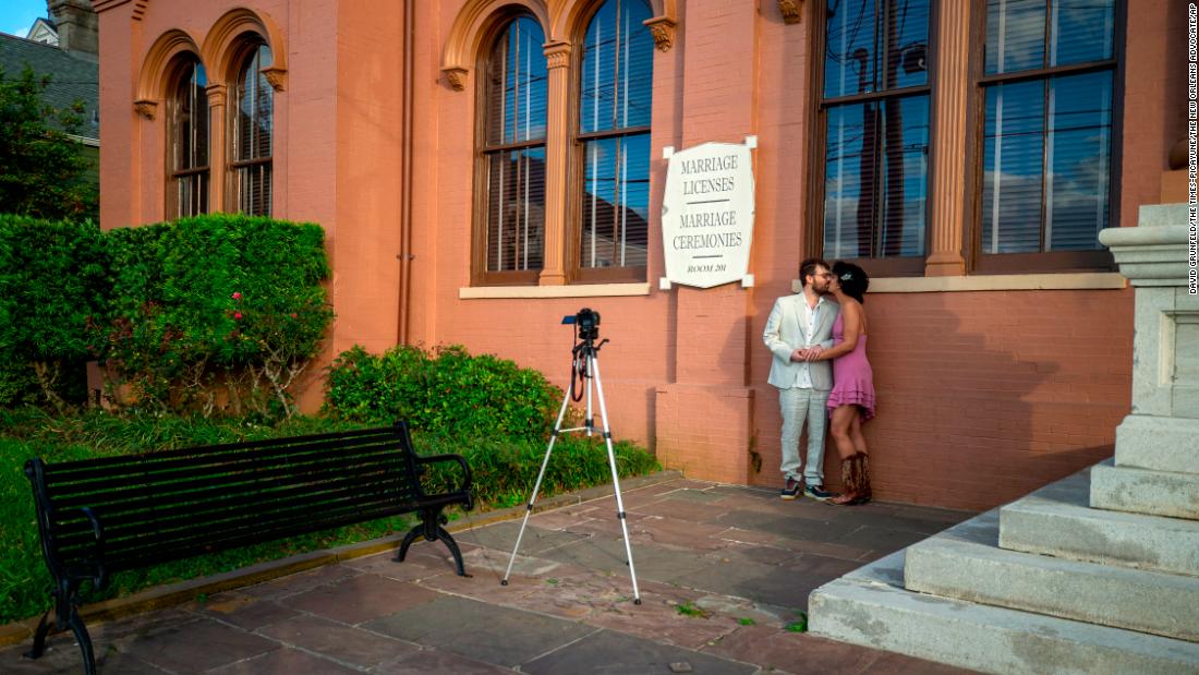Patrick Crilly and Deja Trudeaux, at a distance from their friends and family, kiss after taking their own engagement photograph in front of the Algiers Courthouse in New Orleans on March 31.