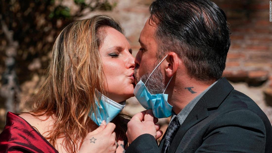 Tatiana Datolla and Armando De Rosa lower their face masks to kiss at their wedding ceremony in Rome on April 11.