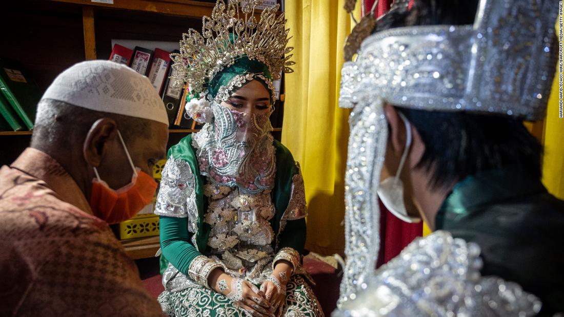 Bride Silviana Dewi, center, and groom Evo Darmawangsah, right, make vows during their wedding ceremony in Siwa, Indonesia, on April 9.