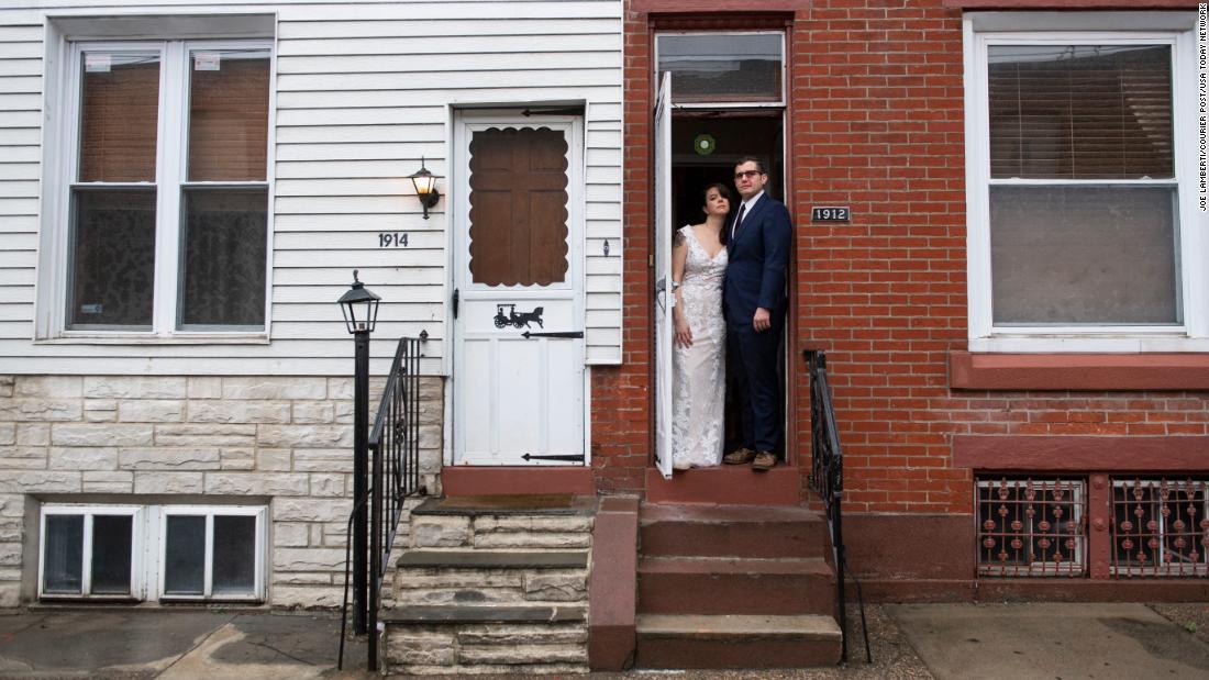 Amelia Ward and Brandon Wright pose in their wedding dress and suit at their home in Philadelphia on March 28. Their wedding was supposed to be the day before in New Orleans, but it was postponed due to the Covid-19 pandemic. They pushed their wedding back a year.