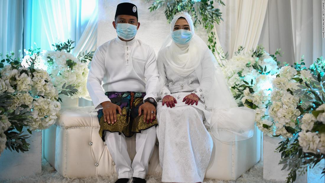 Mohammad Nor Azwan Ishak and Nuramiraalia Noorbashah pose for pictures at a traditional solemnisation ceremony before getting married in a house in Lanchang, Malaysia, on March 20.
