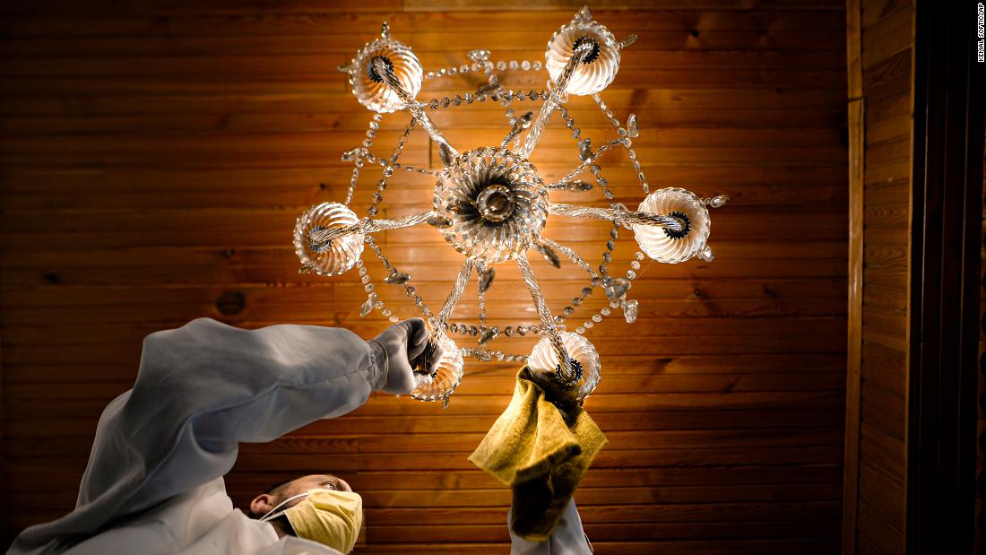 A man disinfects a ceiling lamp at the Čobanija Mosque in Sarajevo, Bosnia and Herzegovina.