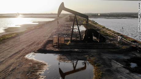 Global oil prices hit 21-year low but stock markets edge higher