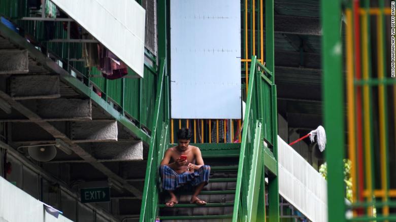 A migrant worker rests on a staircase at a dormitory in Singapore, on April 22.