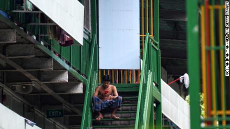 A migrant worker rests on a staircase at a dormitory in Singapore, on April 22.