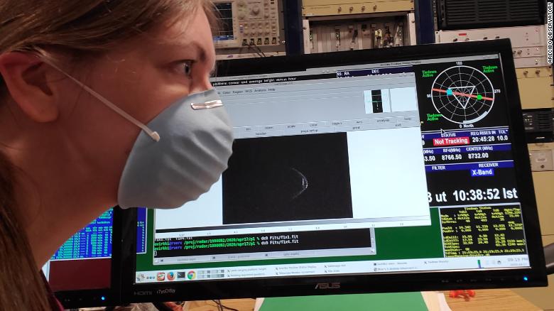 Anne Virkki, the head of planetary radar at the Arecibo Observatory, wears her face mask with a range-Doppler radar image of asteroid 1998 OR2.
