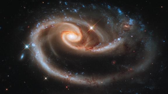 Hubble captured this image of a group of interacting galaxies called Arp 273. The bigger galaxy has a center disk that is distorted into a rose-like shape by the pull from its partner below.