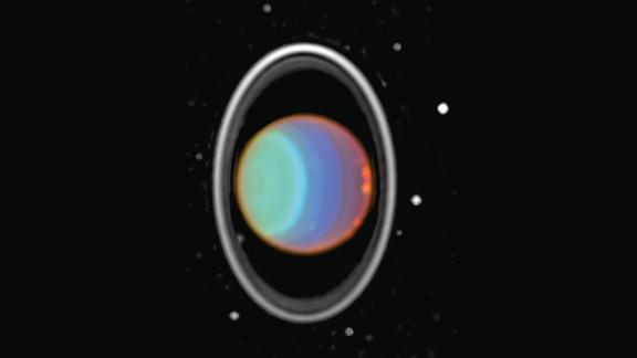 Hubble tracked clouds on Uranus in this image taken in 1997. The image is a composite of three near-infrared images. The planet's rings are prominent in the near infrared. Eight of Uranus' 27 moons can be seen in both images. Uranus is about 1.75 billion miles from Earth.