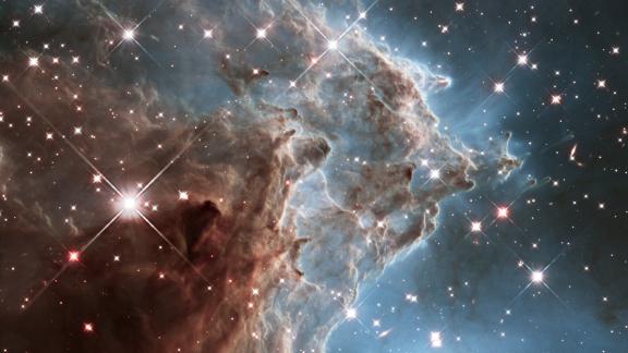 This infrared light image taken by Hubble in 2014 shows the Monkey Head Nebula, where starbirth is occurring 6,400 light-years away from us. Dust clouds and glowing gas swirl together here, representing the ingredients for forming stars.