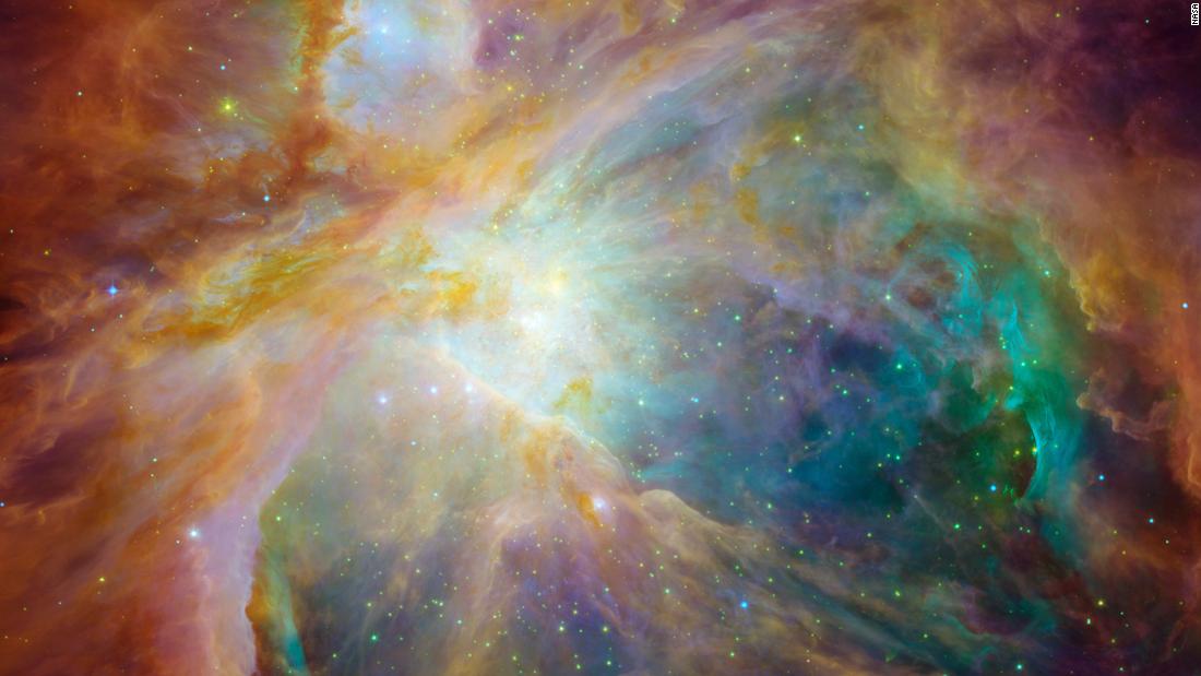 Hubble also teamed up with Spitzer to create this stunning image of the Orion Nebula in 2006. The image combines visible, infrared and ultraviolet light. A community of massive stars is represented by the yellow at the heart of the image.