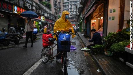 A man wearing a face mask arrives to buy vegetables at a stall in Wuhan in China&#39;s central Hubei province on April 18.