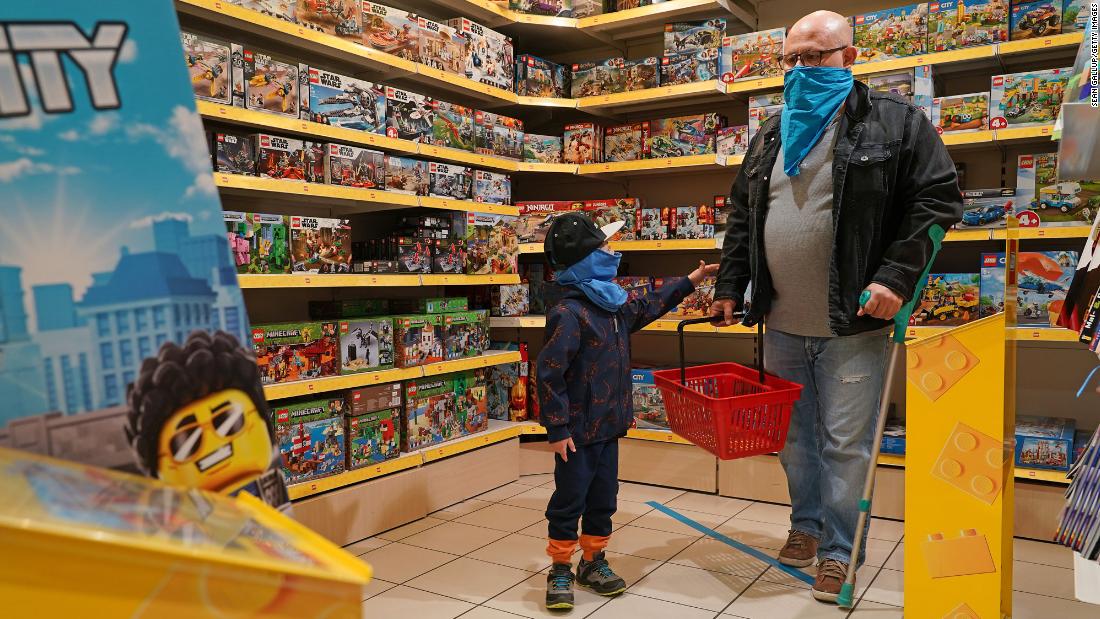 A child and his father shop at a toy store in Berlin that reopened on April 22. It was the first time the store was open since March.
