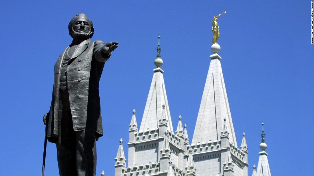 A statue of Brigham Young, second president of the Church of Jesus Christ of Latter-day Saints stands in the center of Salt Lake City, Utah with the Mormon Temple spires in the background.