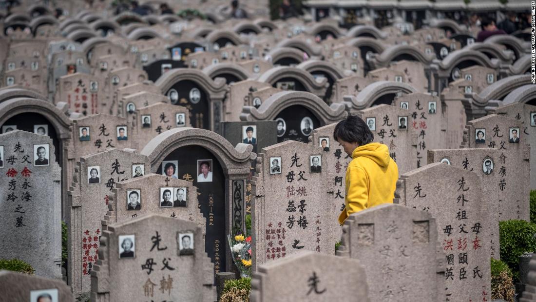 A woman decorates a grave during the Qing Ming festival, also known as Tomb Sweeping Day, at a cemetery in Shanghai on April 6, 2018. Traditional religious practice is growing in China, but the government tightly controls foreign faiths. 