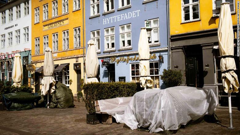 Tables are covered up outside shuttered restaurants in the popular tourist area of Nyhavn in Copenhagen, Denmark, on April 15.