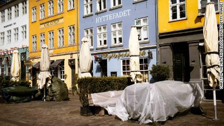 Tables are covered up outside shuttered restaurants in the popular tourist area of Nyhavn in Copenhagen, Denmark, on April 15.