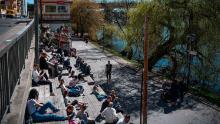 People enjoy the warm spring weather as they sit by the water at Hornstull in Stockholm on April 21.