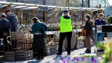 An employee wears a vest reading 