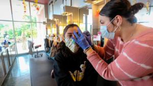 A customer gets her eyebrows waxed at Three-13 Salon, Spa & Boutique on Friday, April 24, 2020, in Marietta, Georgia. The salon had been closed for more than a month due to the new coronavirus. Barber shops, nail salons, gyms and a few other businesses reopened in Georgia on Friday as the Republican governor eased a month-long shutdown despite warnings from health experts of a potential new surge of coronavirus infections. 