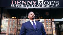 Dennis &quot;Denny Moe&quot; Mitchell, 54, stands outside of Denny Moe&#39;s Superstar Barbershop in Harlem, New York in an undated photo.
