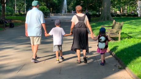 David P. Gelles&#39; parents holding hands with their grandchildren on a walk in Philadelphia in July 2019.