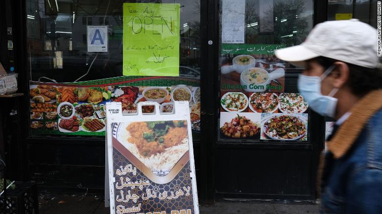 People walk through a New York neighborhood with numerous halal restaurants and grocers on the eve of the Muslim holy month of Ramadan on April 23, 2020. 