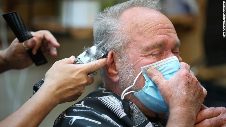 Lonnie Sullivan covers his face with a mask while getting a haircut at The Barber Shop in Broken Arrow, Oklahoma.