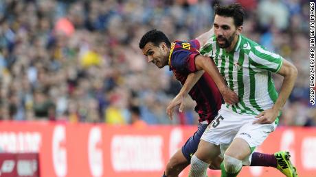Jordi Figueras vies with Barcelona forward Pedro while playing for Real Betis.