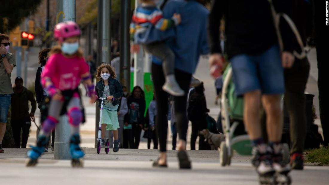 Families walk along a boulevard in Barcelona, Spain, on April 26, 2020.