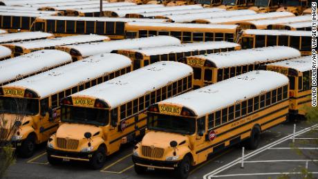 School buses sit parked at the Arlington County Bus Depot, in Virginia. Administrators have to consider how children get to school as well as their time inside.