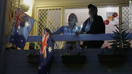 Doreen and Leith Ward pay their respects at dawn from their balcony on April 25, 2020 in Perth, Australia.