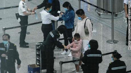 Passengers receive quarantine tracking wrist bands at Hong Kongs international airport on March 19.