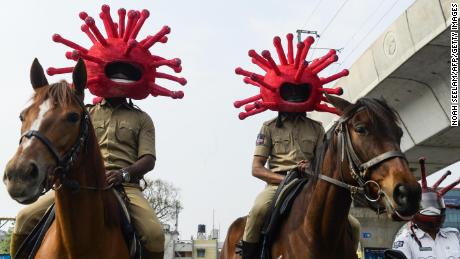 Police personnel wearing coronavirus-themed helmets ride on horses as they participate in a awareness campaign in Secunderabad, the twin city of Hyderabad, on April 2, 2020. 