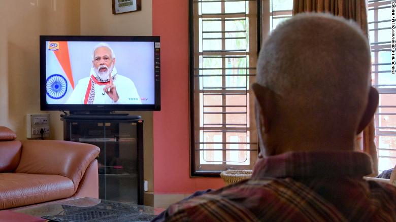 A senior citizen watches Modi address the nation on a television broadcast during India&#39;s government-imposed coronavirus lockdown.