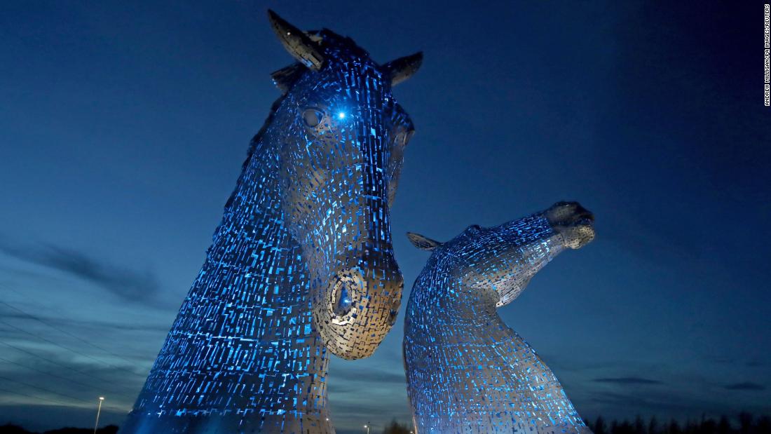 The Kelpies sculpture in Falkirk, Scotland, is illuminated by blue light as a tribute to the United Kingdom&#39;s National Health Service and social-care workers on April 7.