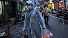 A person wearing a face mask as a preventive measure against the spread of the new coronavirus COVID-19 carries groceries in a neighborhood in Wuhan, China's central Hubei province, on April 20.