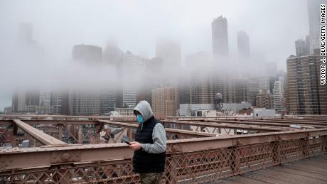 NEW YORK, NY - MARCH 20: A man wearing a mask walks the Brooklyn Bridge in the midst of the coronavirus (COVID-19) outbreak  on March 20, 2020 in New York City. The economic situation in the city continued to decline as New York Gov Andrew Cuomo ordered all nonessential businesses to keep all their workers at home and New York weighed a shelter in place order for the entire city. (Photo by Victor J. Blue/Getty Images)