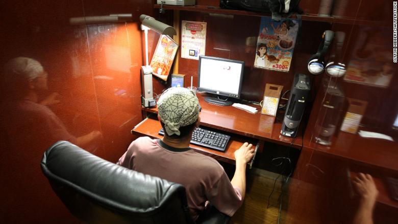 A man relaxes in his private booth where he will spend the night, in one of Tokyo&#39;s many 24-hour internet cafes, which provide the capital&#39;s homeless with a roof over their heads.