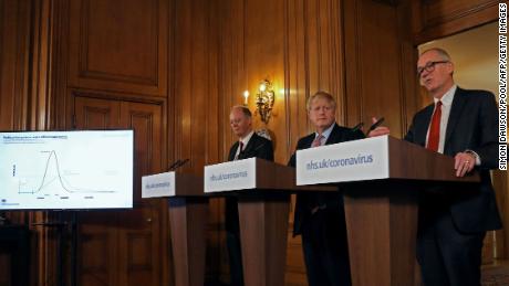 Boris Johnson, center, is flanked by the Chief Medical Officer for England, Chris Whitty, left, and Chief Scientific Adviser Patrick Vallance at a March 12 news conference.