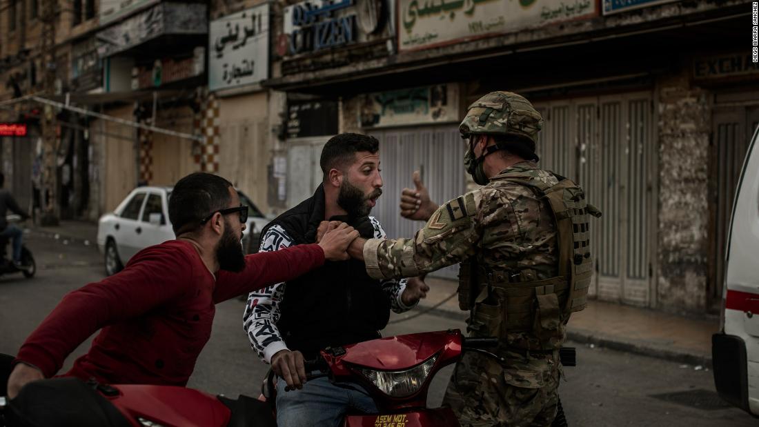 A soldier stops a man on a motorcycle during Tuesday&#39;s clashes.