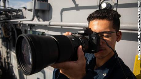 US Navy Spec. Kevin Rodruigez, from Hartford, Md., takes a picture of a surface contact from aboard the guided-missile cruiser USS Bunker Hill on Wednesday near the Spratly Islands in the South China Sea.