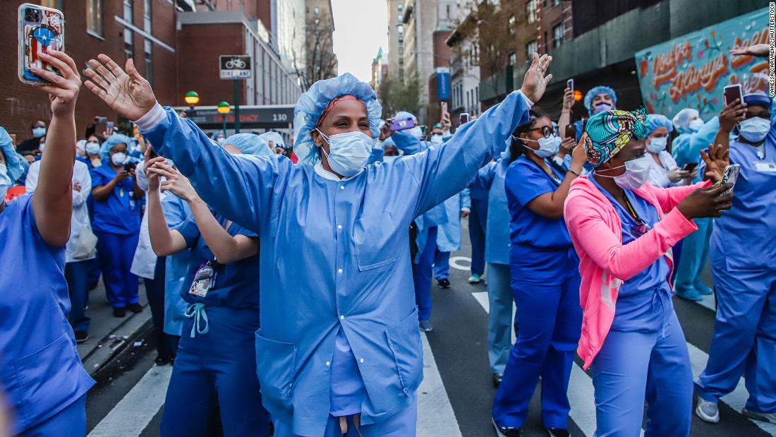 Health-care workers wave back to people applauding them in New York City on April 15.