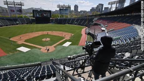 A cameraman records footage among empty stands during a pre-season baseball game between Seoul-based Doosan Bears and LG Twins at Jamsil stadium in Seoul on April 21, 2020. Professional sport returned to South Korea on April 21 as coronavirus restrictions ease.