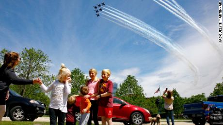 The Ferry family from Chantilly, Virginia, is surprised by a second flyover by the Blue Angels and Thunderbirds seen near the Marine Corps War Memorial in Arlington, Virginia, on Saturday.