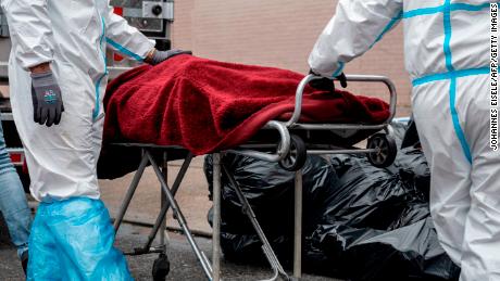 TOPSHOT - People in Hazmat suits transport a deceased body on a stretcher outside a funeral home in Brooklyn on April 30, 2020 in New York City. - Dozens of bodies have been discovered in unrefrigerated overflow trucks outside the Andrew T. Cleckley Funeral Home, following a complaint of a foul odor. (Photo by Johannes EISELE / AFP) (Photo by JOHANNES EISELE/AFP via Getty Images)