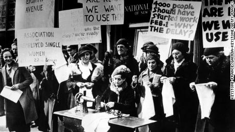 Unemployed workers demonstrate outside government offices to demand jobs during the Depression.