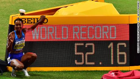 Muhammad poses next to the screen reading the new world record she set in the Women&#39;s 400m hurdles at the 2019 IAAF Athletics World Championships at the Khalifa International stadium.