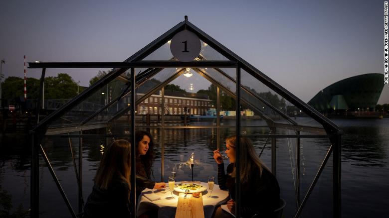 A group of friend have dinner in a so-called quarantine greenhouses in Amsterdam, on May 5, 2020 as the country fights against the spread of the COVID-19, the novel coronavirus.