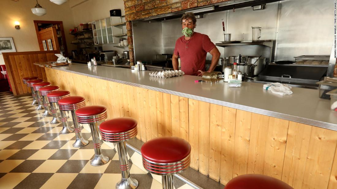 Travis Medlock, owner of the Little Shop of Ramen, looks over a row of empty stools inside his restaurant in Mariposa, California, on April 29. During the coronavirus pandemic, Medlock now only takes orders to go. 