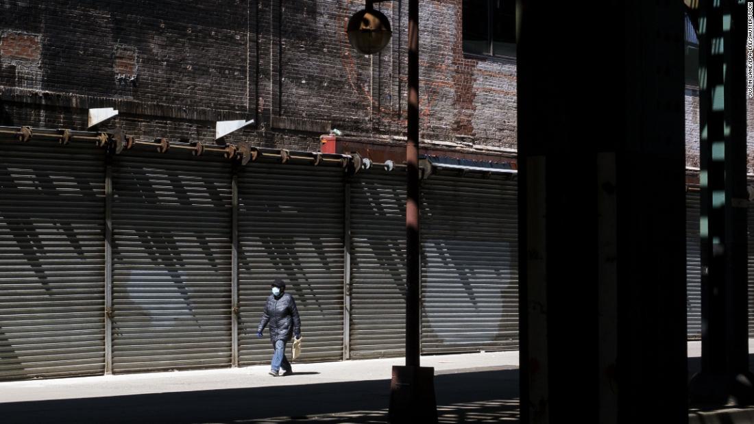 A person walks past shuttered storefronts in the Bronx as all nonessential businesses in New York were ordered closed during the pandemic. 